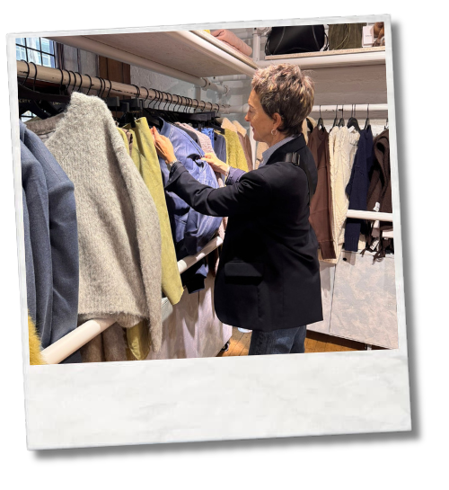 Person selecting clothes from a wardrobe rail indoors