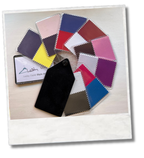 Fan of fabric colour swatches arranged on a table with a sample card