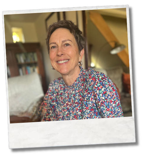 Smiling person sitting indoors wearing a patterned top
